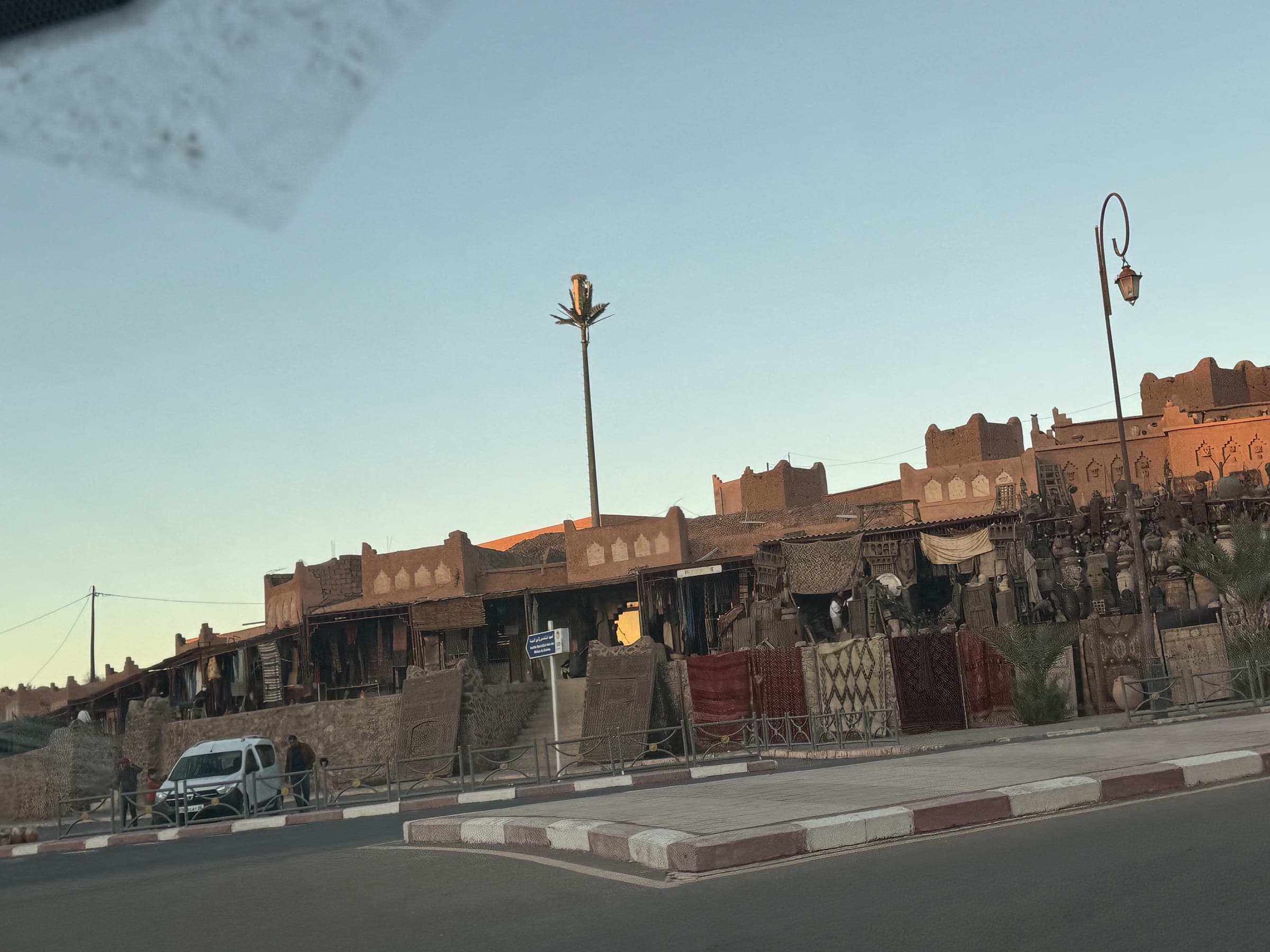 Mercado de artesanía y alfombras en Ouarzazate con arquitectura de adobe al atardecer, Marruecos