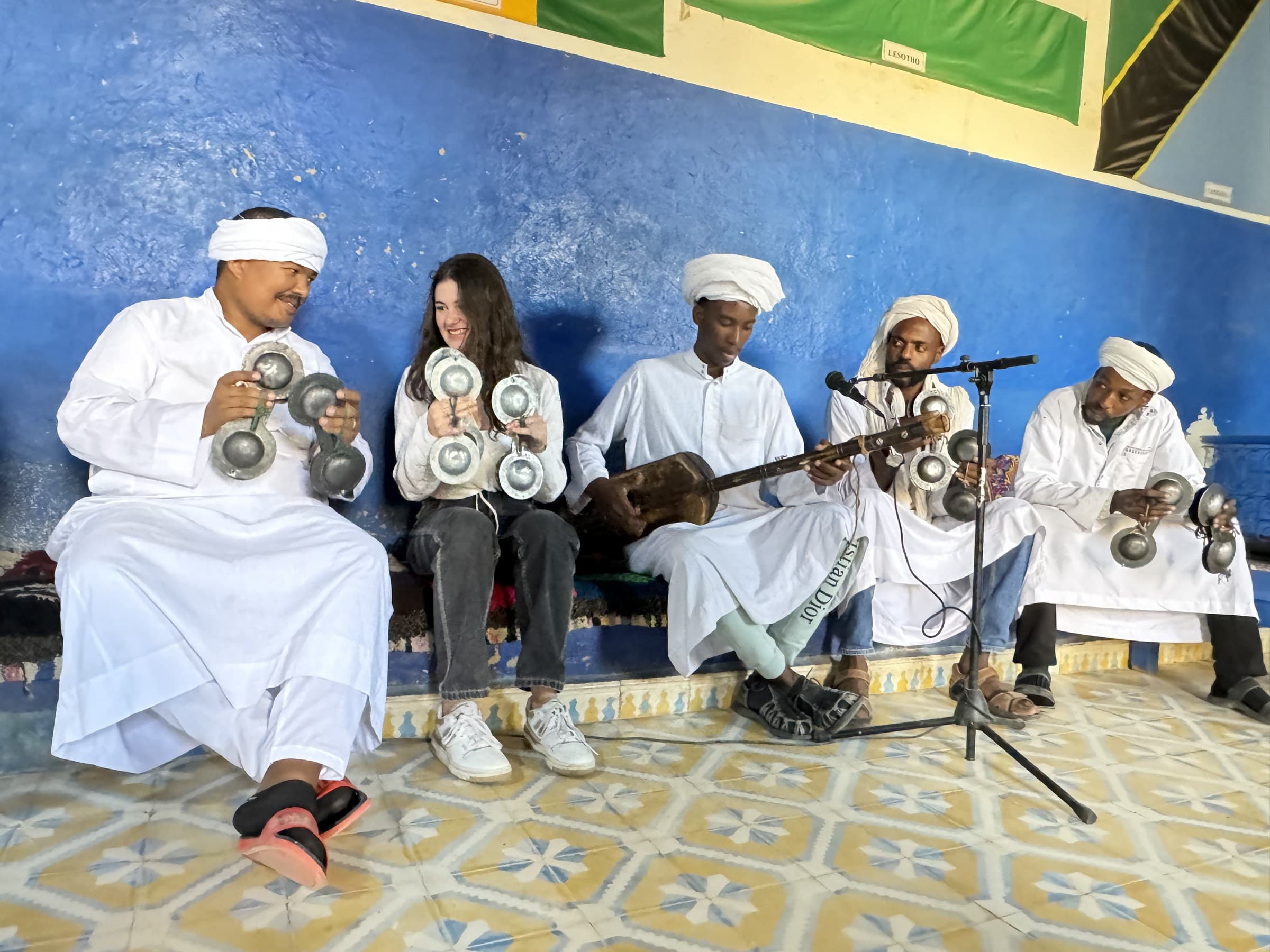 Viajera tocando las crótalas metálicas junto a músicos Gnawa en Khamlia, desierto de Merzouga, Marruecos