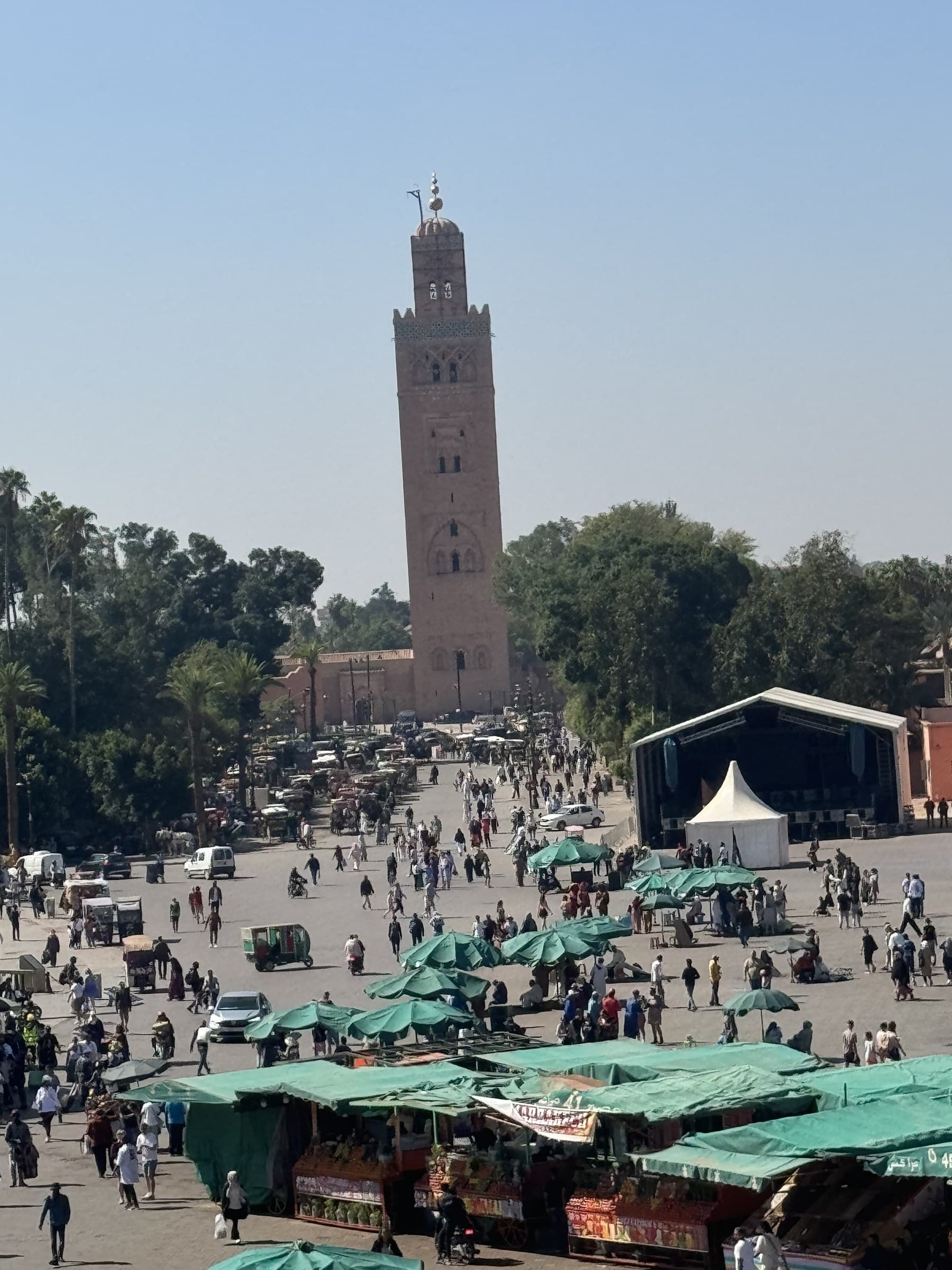 Plaza Jemaa el-Fna de Marrakech con la mezquita Koutoubia al fondo y puestos de mercado en primer plano