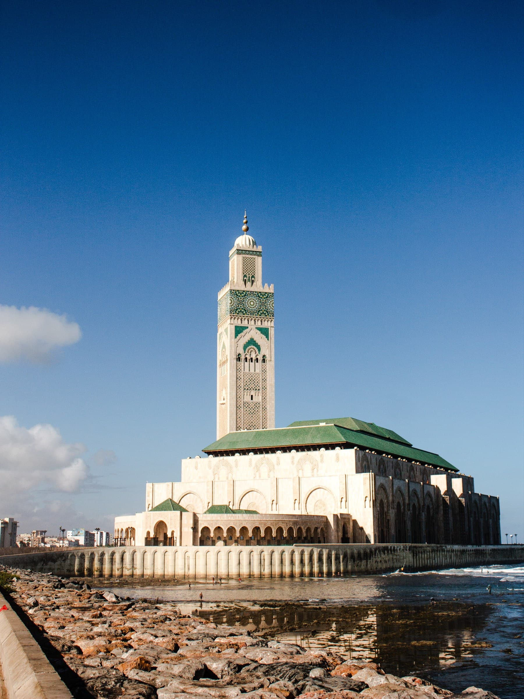Mezquita Hassan II de Casablanca sobre el Atlántico, con su gran minarete y fachada de mármol blanco bajo cielo azul