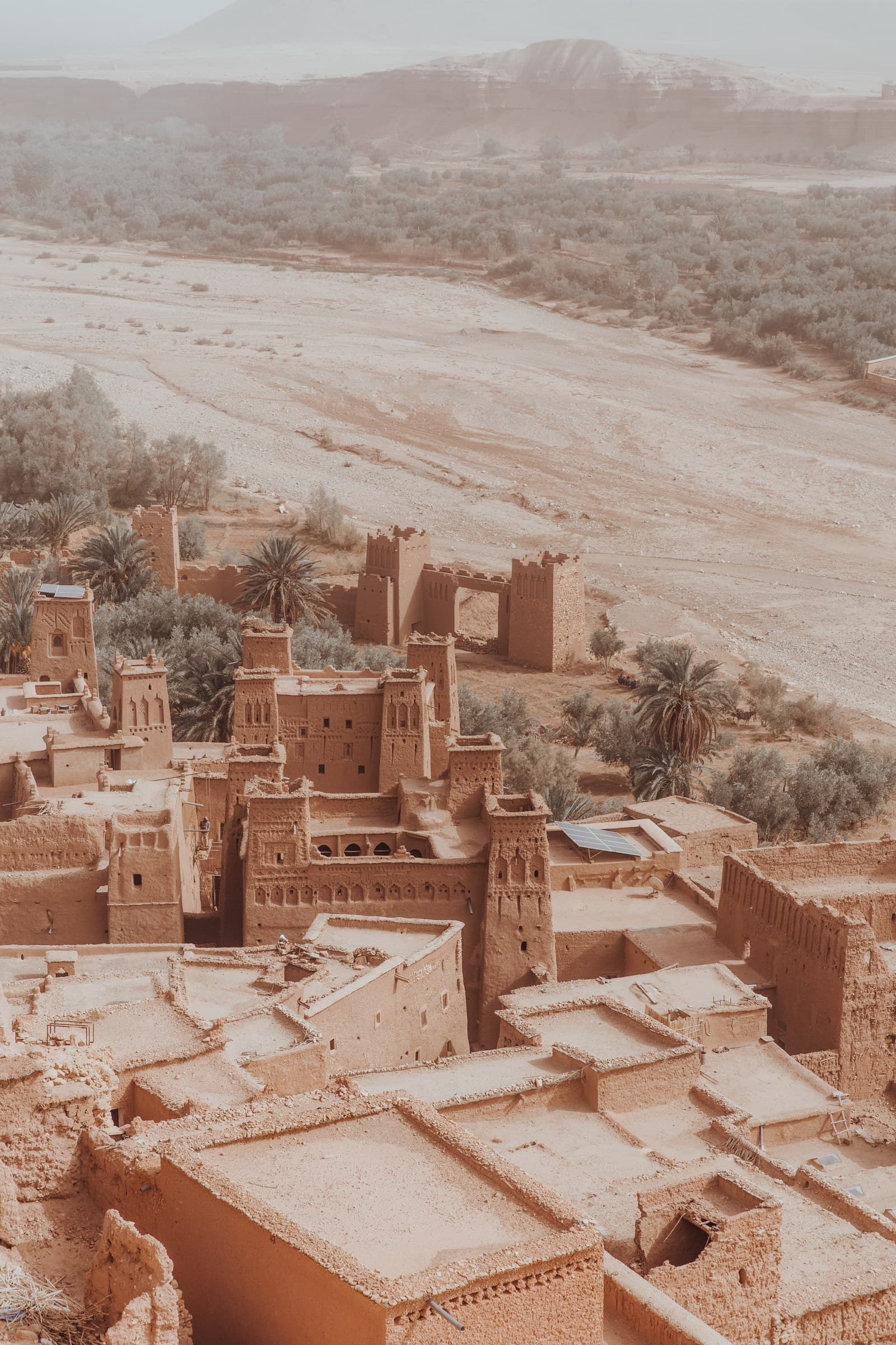 Vista aérea de la kasbah de Aït Ben Haddou, patrimonio UNESCO, con sus torres de barro ocre y palmeras en Marruecos